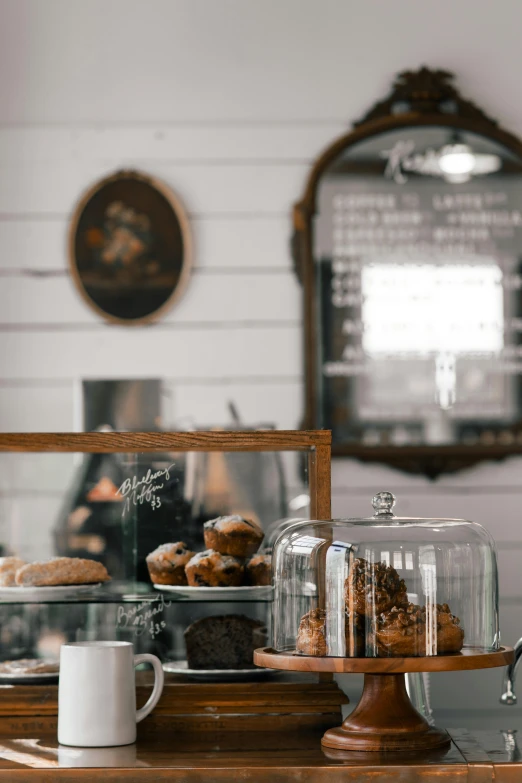 a wooden table topped with cakes and pastries, trending on pexels, jar on a shelf, thumbnail, storefront, good light