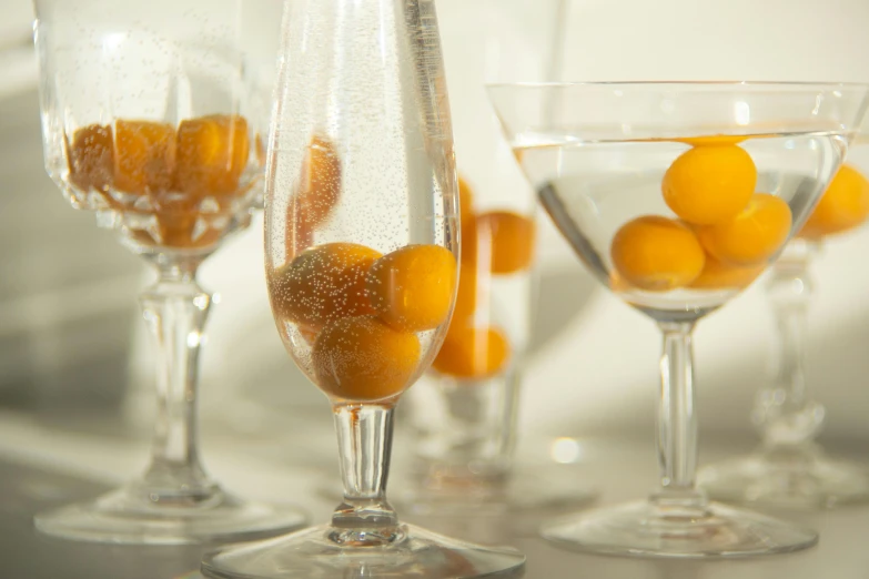 a group of wine glasses filled with oranges, metaballs, cocktail bar, bubbles, glassware