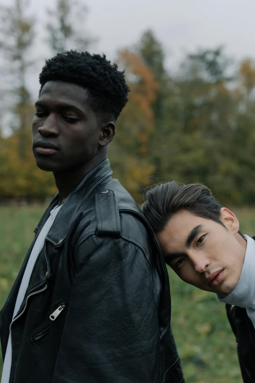 two men standing next to each other in a field, trending on pexels, renaissance, adut akech, non binary model, asian features, wearing a black jacket