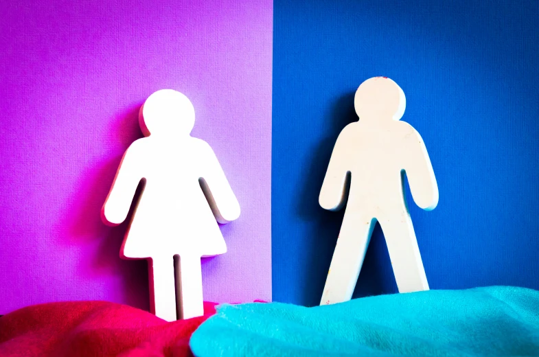 a paper cutout of a man and a woman standing next to each other, by Arabella Rankin, trending on unsplash, magenta and blue, white and pink cloth, board games on a table, transgender