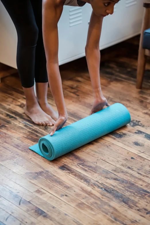 a woman rolling up a yoga mat on the floor, by Carey Morris, pexels contest winner, square, teal paper, standing up, high resolution