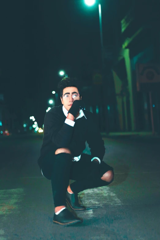 a man squatting in the middle of a street at night, an album cover, pexels contest winner, wearing a fancy black jacket, diego fernandez, 15081959 21121991 01012000 4k, headshot profile picture