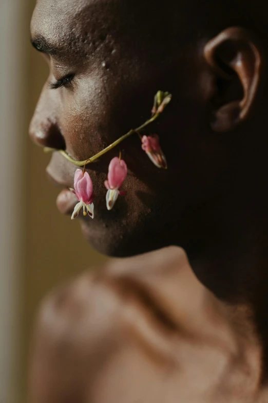 a man with a flower in his mouth, by Lily Delissa Joseph, trending on pexels, made of flowers and berries, black young woman, brown and pink color scheme, neck zoomed in from lips down