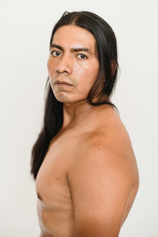 a man with long hair posing for a picture, inspired by Jorge Jacinto, bare chest, looking to the side off camera, indigenous man, lean man with light tan skin