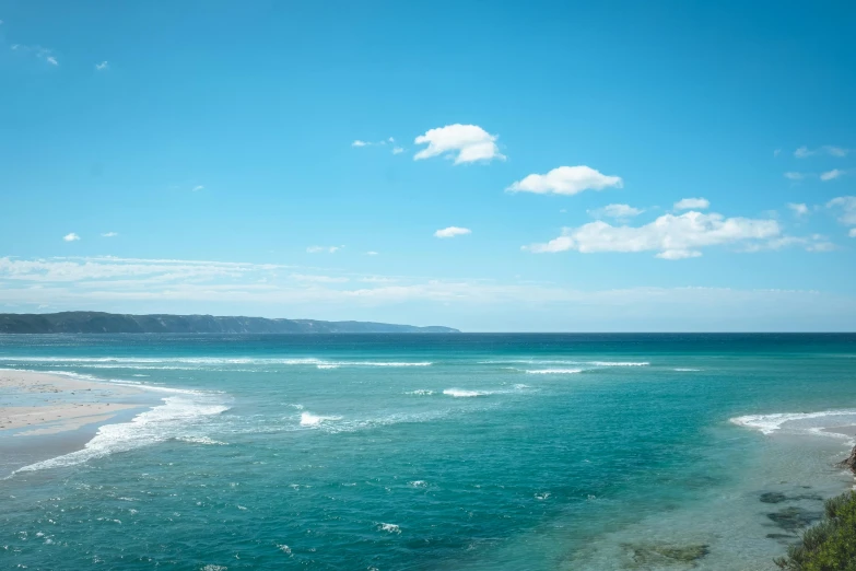 a view of the ocean from the top of a hill, unsplash, renaissance, azure blue sky, bulli, wavy water, midday photograph