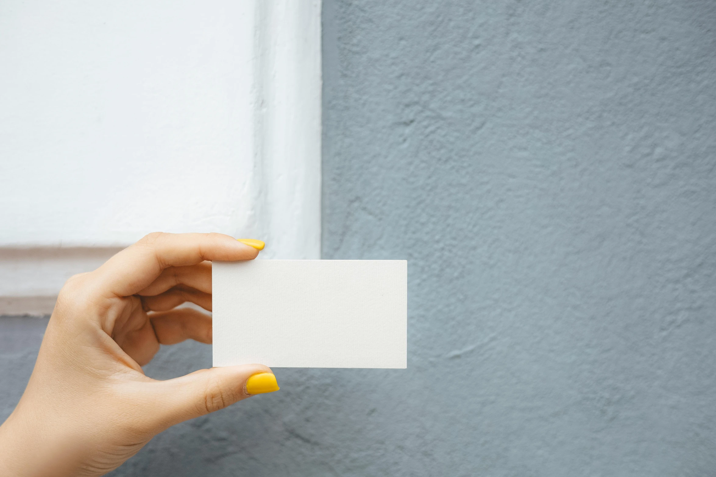 a woman's hand holding a business card against a blue wall, pexels contest winner, private press, square, plain white background, enamel, customers