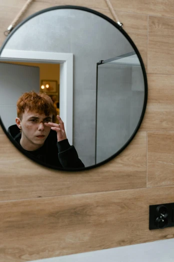 a man taking a picture of himself in a mirror, an album cover, trending on pexels, red haired teen boy, oval eyes, non binary model, hotel room