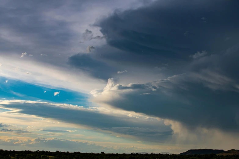 a couple of cows standing on top of a lush green field, by Peter Churcher, unsplash contest winner, towering cumulonimbus clouds, new mexico, panorama view of the sky, dark night stormcloud