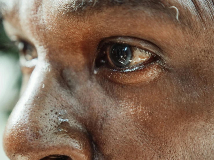 a close up of a person with brown eyes, by Daniel Lieske, trending on unsplash, african man, wet reflections in square eyes, detailed faces looking up, close up shot a rugged