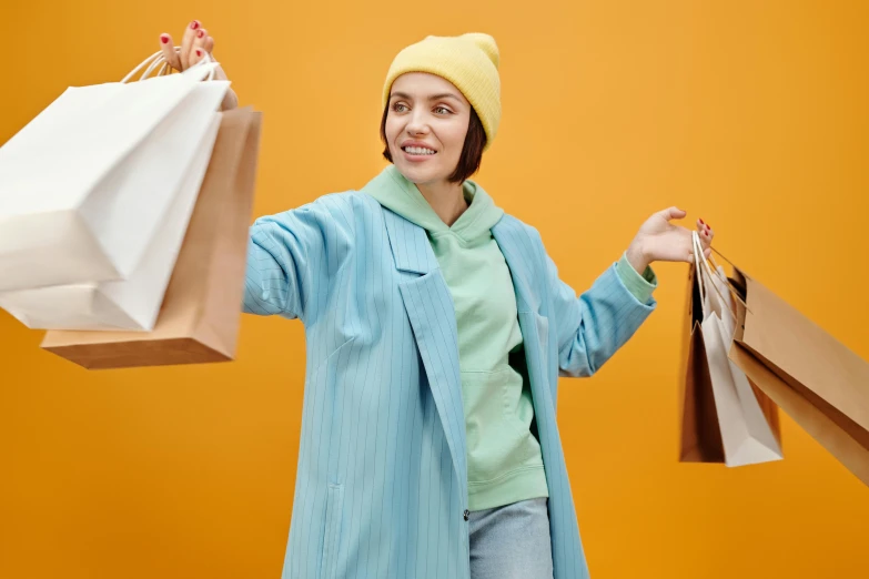 a woman in a blue coat holding shopping bags, trending on pexels, figuration libre, wearing a yellow hoodie, avatar image, pastel clothing, wearing festive clothing