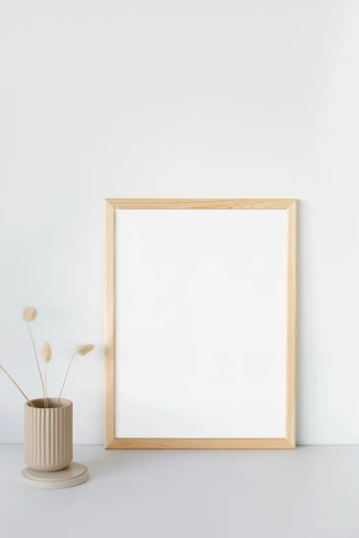a picture frame sitting on top of a table next to a vase, postminimalism, light wood, whiteboard, blond, a blond
