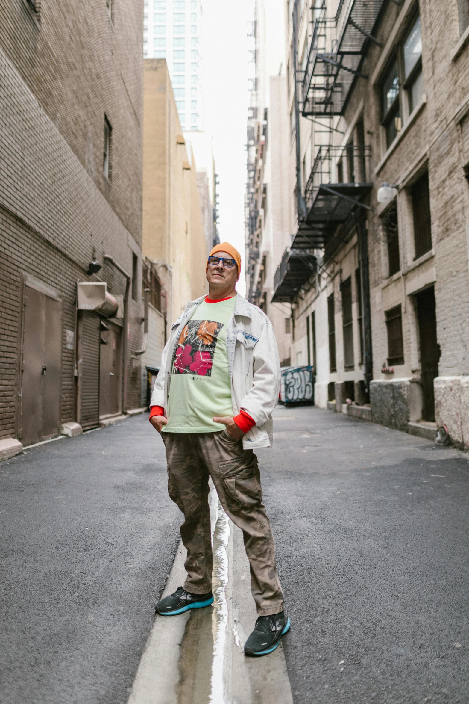 a man standing in the middle of a city street, an album cover, inspired by Bruce Gilden, unsplash, graffiti, an epic non - binary model, wearing sunglasses and a cap, peter griffin in real life, alleys