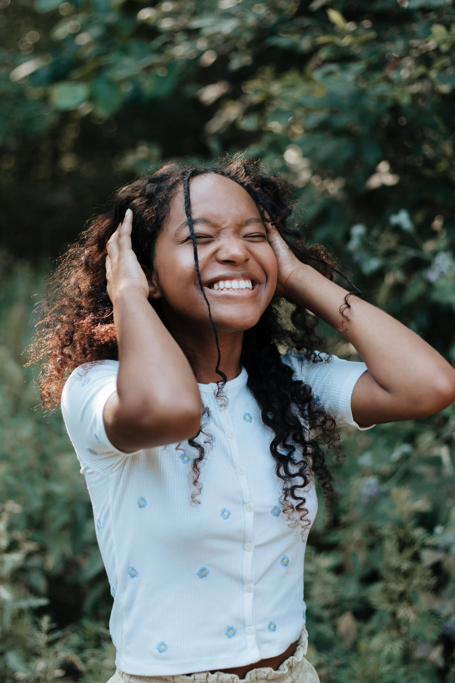 a woman standing in the woods with her hands on her head, pexels contest winner, happening, earing a shirt laughing, a black man with long curly hair, black teenage girl, large smile