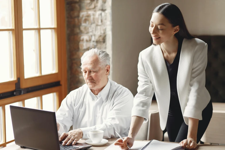 a woman standing next to a man on a laptop, by Gavin Hamilton, pexels contest winner, renaissance, hide the pain harold, sitting at desk, profile image, no - text no - logo