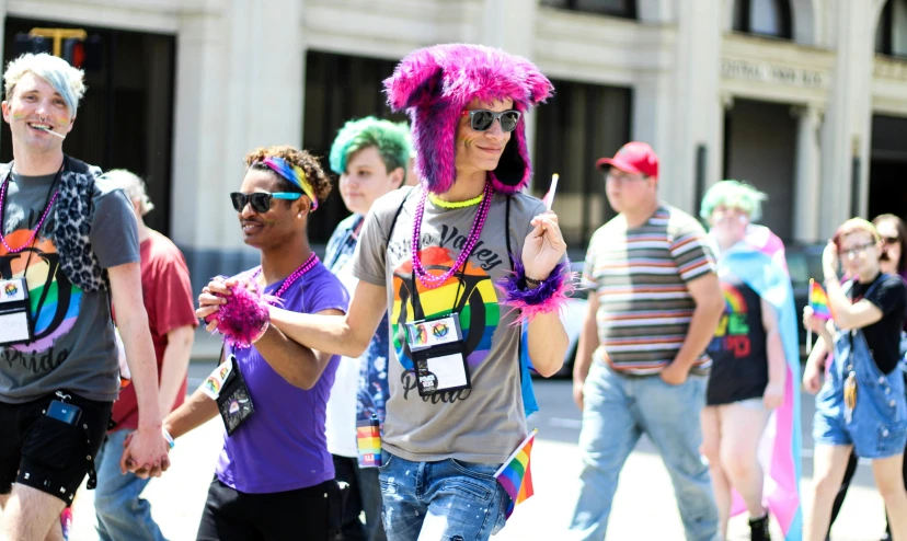 a group of people walking down a street, leslie david and lisa frank, pride, wearing sunglasses and a cap, adafruit