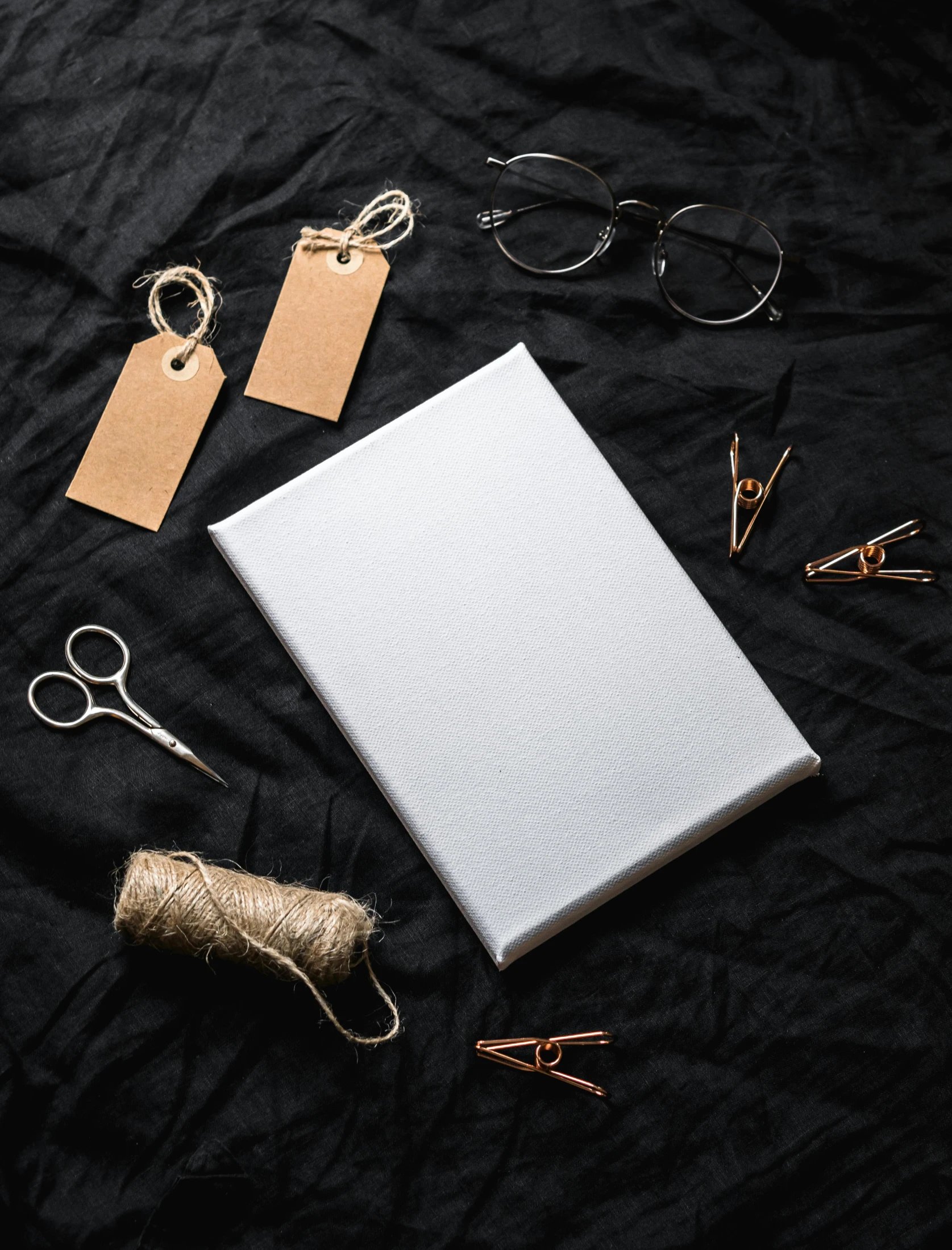a book sitting on top of a table next to a pair of scissors, an album cover, pexels contest winner, gray canvas, product introduction photo, holiday, plastic and fabric