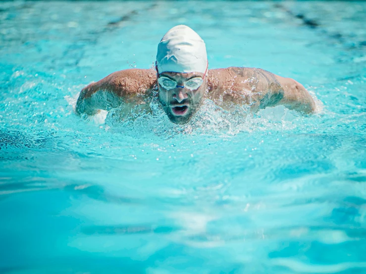 a man swimming in a pool with goggles on, square, college, performing, digital image