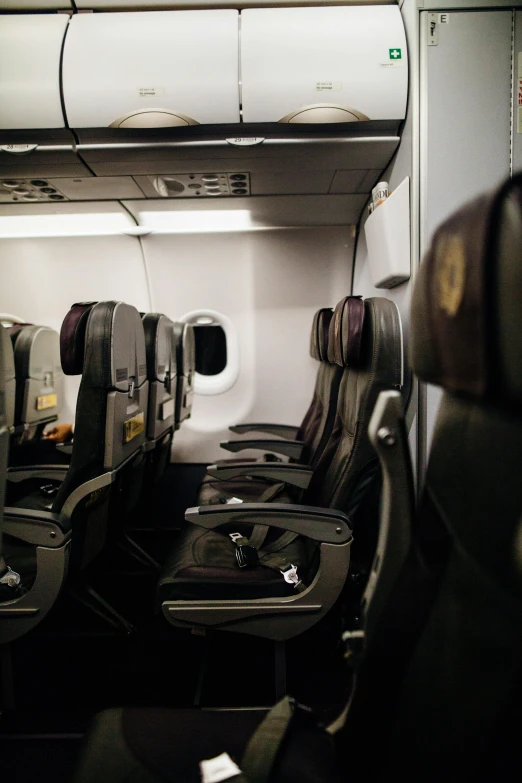 a row of empty seats in an airplane, by Peter Churcher, unsplash, gold and black color scheme, instagram picture, panel of black, in 2 0 1 5