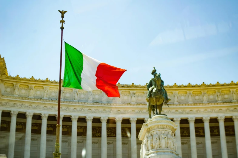 a statue of a man holding a flag in front of a building, a statue, by Giorgio De Vincenzi, pexels contest winner, square, italian flag, m, top