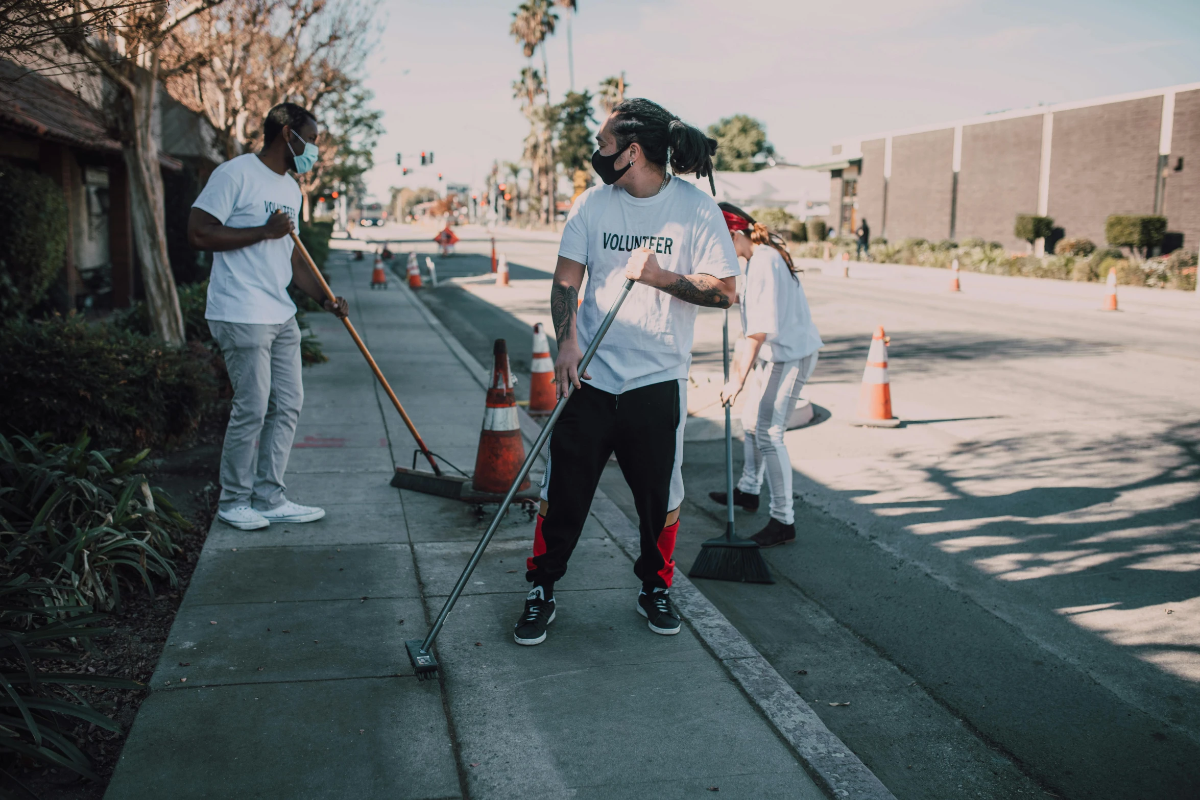 a group of people standing on the side of a road, by Ryan Pancoast, pexels contest winner, happening, cleaned up, sweeping, nipsey hussle, gardening