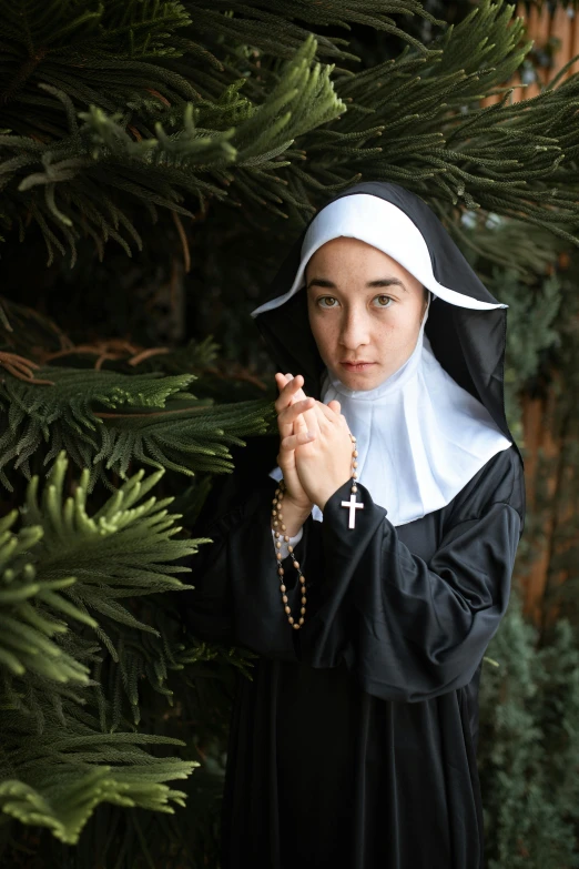 a woman dressed as a nun holding a rosary, a portrait, shutterstock, lush surroundings, dilraba dilmurat, lgbtq, ( ( theatrical ) )