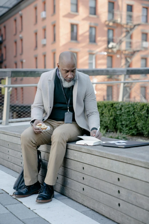 a man sitting on a bench reading a book, a portrait, inspired by David Garner, pexels contest winner, harlem, having a snack, business attire, movie filmstill