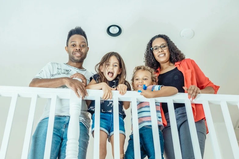 a group of people standing on top of a white railing, a portrait, by Washington Allston, pexels contest winner, les nabis, happy family, indoor picture, mkbhd, no words 4 k