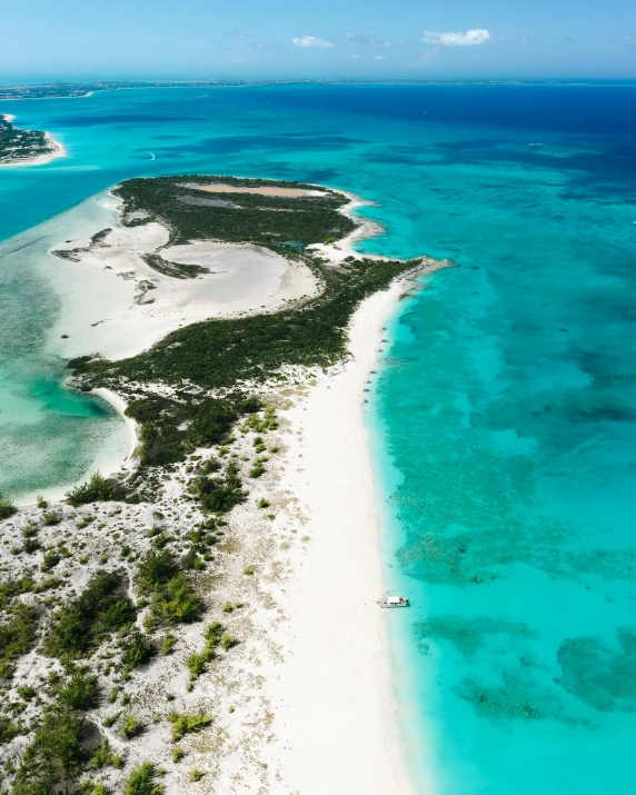 an aerial view of an island in the middle of the ocean, white sandy beach, teals, thumbnail, conde nast traveler photo