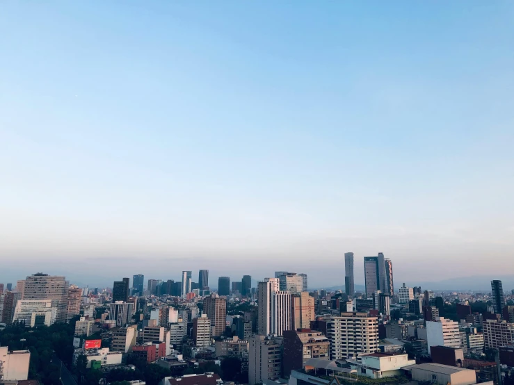 a view of a city from the top of a building, unsplash, mingei, sunny clear sky, rinko kawauchi, skyline showing, afternoon