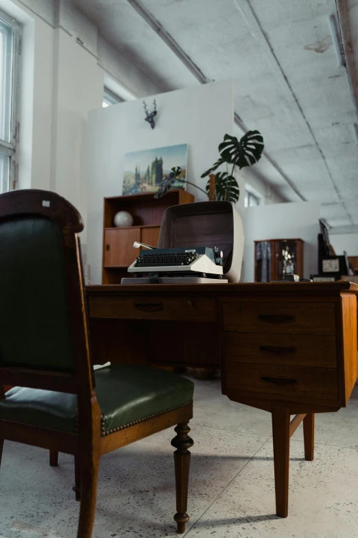 a desk with a typewriter sitting on top of it, by Andries Stock, backrooms office space, luxurious environment, fan favorite, facing away