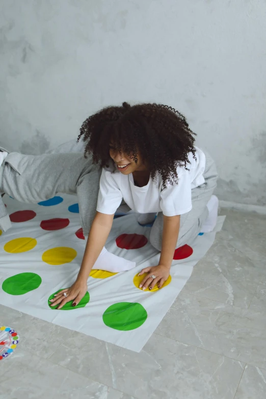 a woman sitting on top of a bed next to a child, shutterstock contest winner, interactive art, twister, game board, primary colors, polkadots