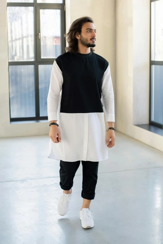 a man in a black and white shirt and black pants, inspired by Hiromitsu Takahashi, hurufiyya, white long tanktop, color block, islamic, ready - made