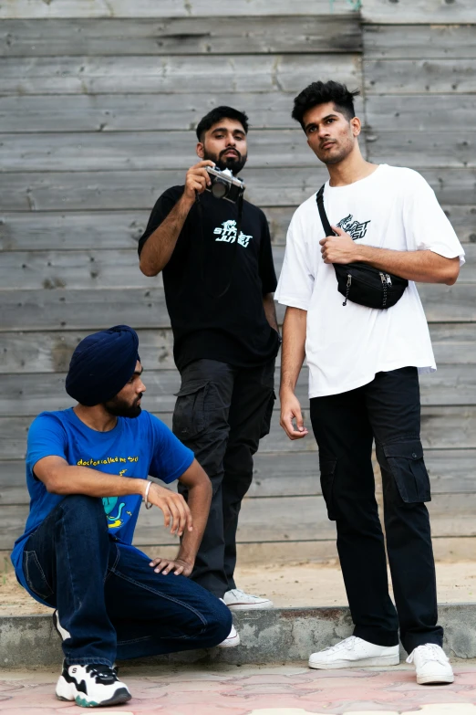 a group of young men standing next to each other, a portrait, inspired by Manjit Bawa, skateboarder style, wearing a baggy, federation clothing, looking away from camera