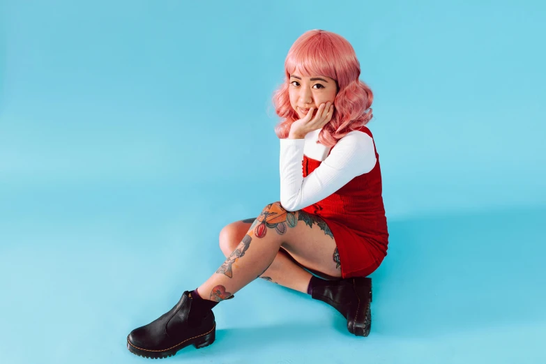 a woman with pink hair sitting on a blue surface, inspired by Yuko Tatsushima, trending on pexels, red boots, comic pinup style, wearing a pink dress, of taiwanese girl with tattoos