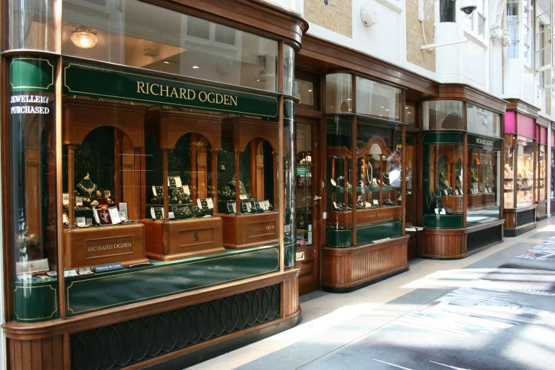 a row of jewelry stores on a city street, a photo, by Rachel Reckitt, arts and crafts movement, an elegant green, richard rider, in magnificent shopping mall, profile image