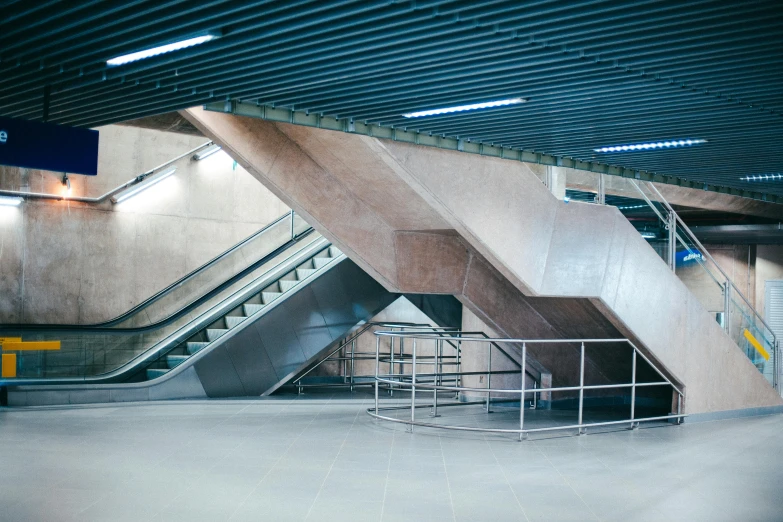 a man riding a skateboard up the side of an escalator, inspired by Zaha Hadid, unsplash, brutalism, bus station, an empty brutalist chamber, stairs to an upper floor, an intricate