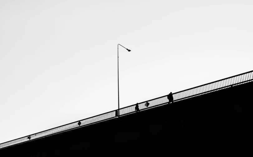 a black and white photo of a bridge, by Karl Buesgen, unsplash, postminimalism, silhouettes of people, lampposts, fine art print, minimal outlines