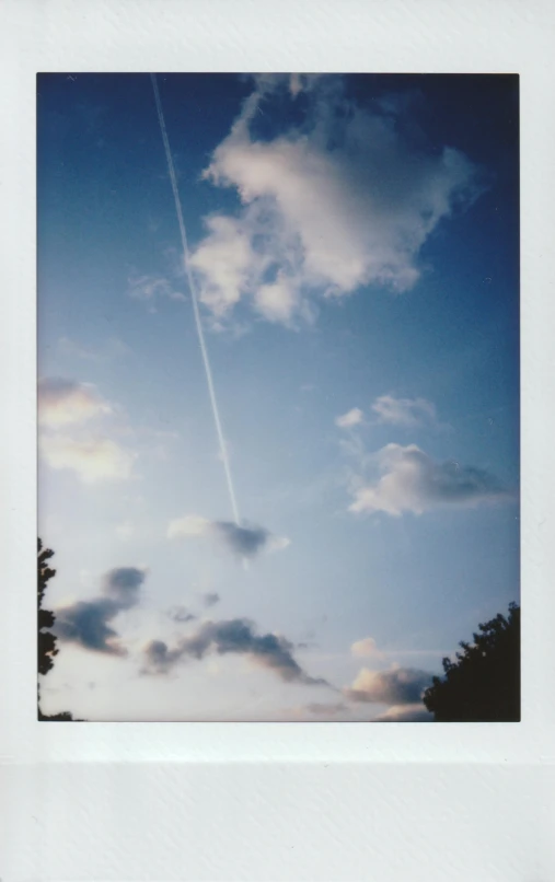 a polaroid picture of a plane flying in the sky, by Adam Pijnacker, late summer evening, instax, low quality photo, cinematic shot ar 9:16 -n 6 -g