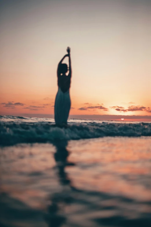 a woman standing in the ocean at sunset, unsplash, renaissance, dancing elegantly over you, grainy, instagram post, high quality image