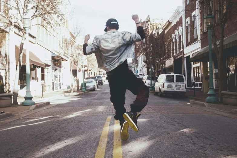 a man riding a skateboard down the middle of a street, pexels contest winner, happening, jumping for joy, mac miller, caleb worcester, gritty distopian