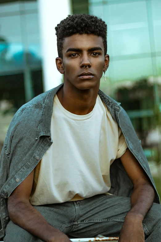 a young man sitting on top of a skateboard, by Cosmo Alexander, trending on pexels, photorealism, with brown skin, strong jawline, non binary model, headshot profile picture