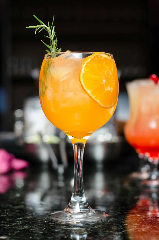 a close up of a drink in a glass on a table, very orange, daily specials, knockout punch, summer night