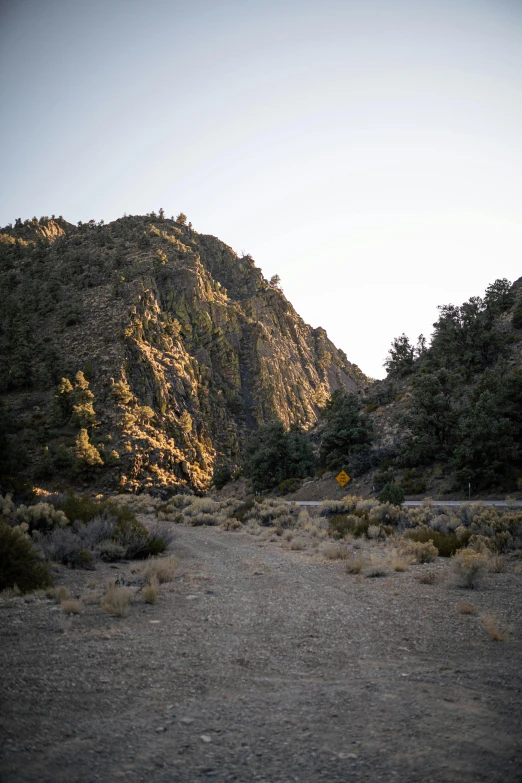 a dirt road with a mountain in the background, canyon, very low light, campsites, palm springs