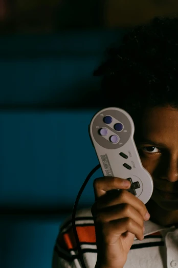 a young boy holding a video game controller, inspired by Gordon Parks, unsplash, neogeo, serious face, afro tech, discord profile picture, late night