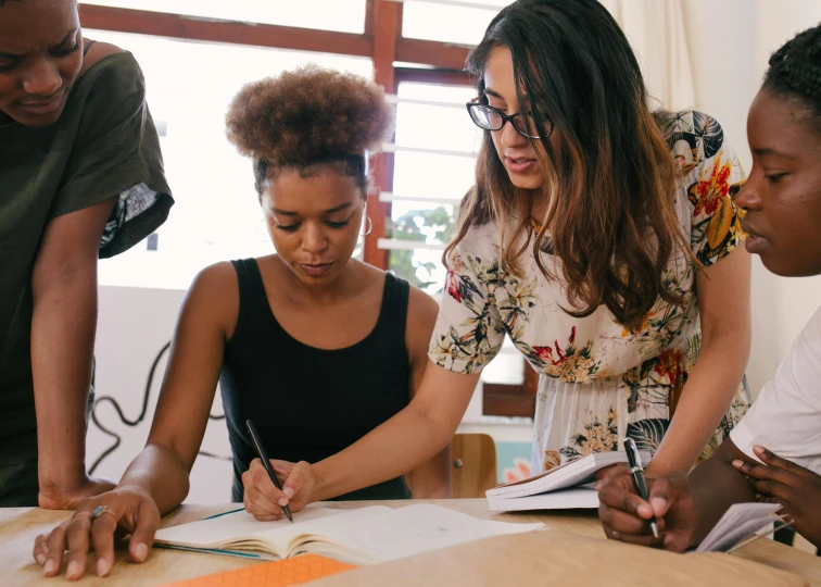 a group of people sitting around a wooden table, pexels contest winner, academic art, sharpie, woman holding another woman, teaching, 9 9 designs