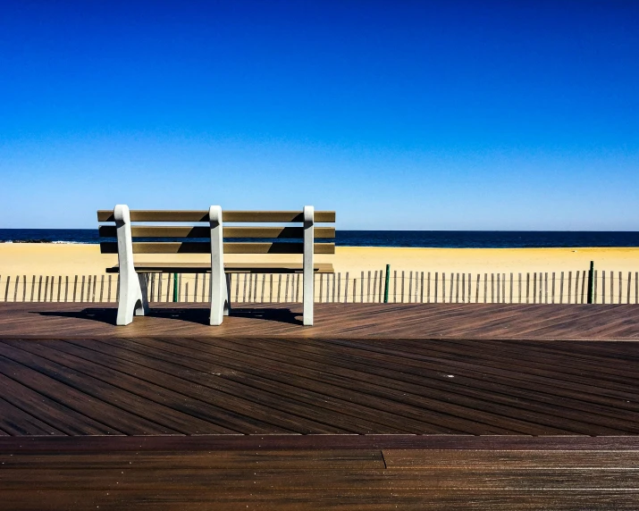 a wooden bench sitting on top of a wooden deck, by Niko Henrichon, trending on unsplash, victorian arcs of sand, new jersey, three views, boardwalk