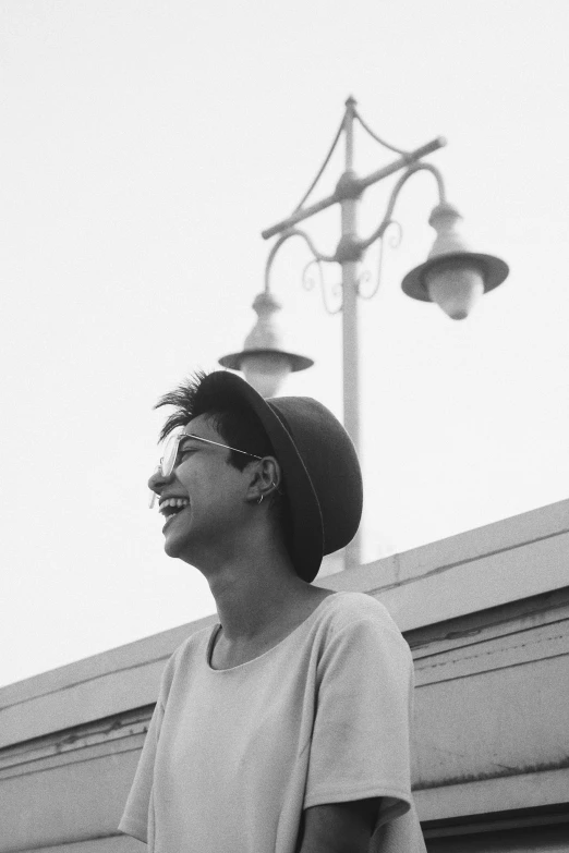 a black and white photo of a man holding a skateboard, by Nathalie Rattner, portrait of priyanka chopra, she is laughing, looking at the sky, androgynous person