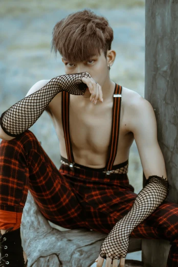 a man sitting on top of a rock next to a tree, an album cover, inspired by Kim Deuk-sin, trending on pexels, renaissance, fishnets stockings, tartan garment, physical : tinyest midriff ever, twink