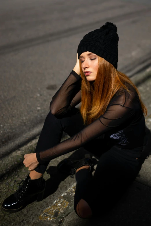 a woman sitting on the side of a road, inspired by Elsa Bleda, trending on pexels, renaissance, black beanie, wearing a black bodysuit, thinking pose, sheer