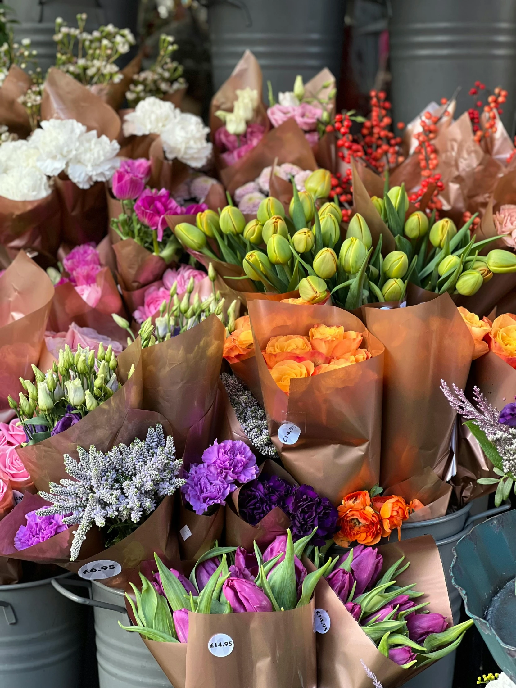 a bunch of buckets filled with lots of flowers, roses and tulips, vibrant muted colors, wrapped in flowers, commercially ready